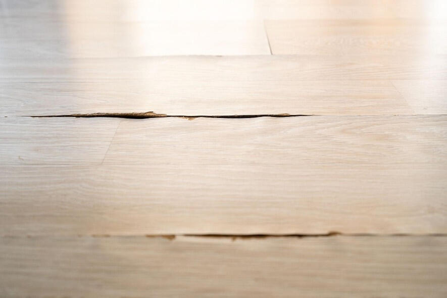 Severe chipping and delamination of the flooring surface.